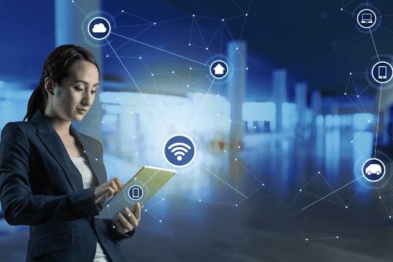Businesswoman using tablet with RFID technology icons representing connectivity for asset and inventory tracking.